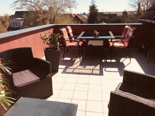 a patio with chairs and a table on a balcony at Centralt i Gentofte i 2 plan, ved S-Tog og busser in Gentofte