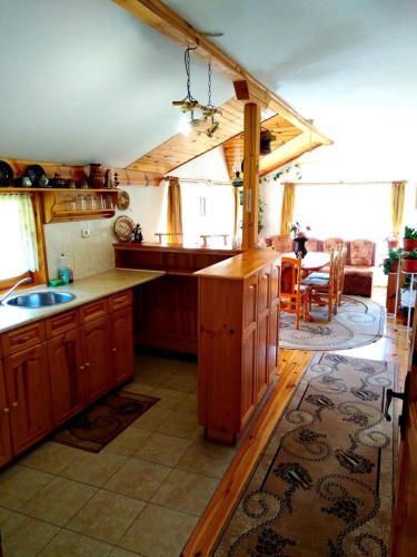 a large kitchen with wooden cabinets and a table at вила Здравец in Yagodina