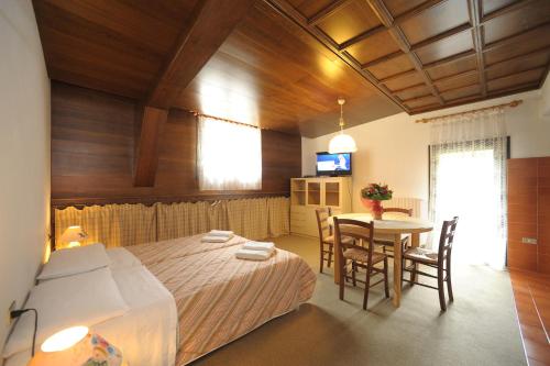 a bedroom with a bed and a table with chairs at Residence Regina Delle Dolomiti in Rocca Pietore