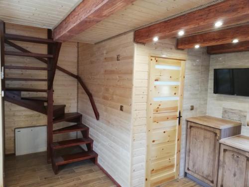 a log cabin with a staircase and a tv at Domki letniskowe KAMA Polańczyk 514-280-102 in Solina