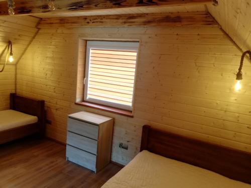 a room with two beds and a window at Domki letniskowe KAMA Polańczyk 514-280-102 in Solina