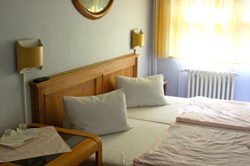 a bedroom with a bed with white sheets and pillows at Penzion Nikola in Pec pod Sněžkou