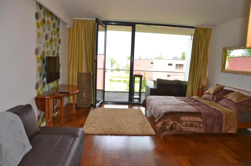a bedroom with a bed and a couch and a living room at Modern Apartment with Lake View in Balatonlelle