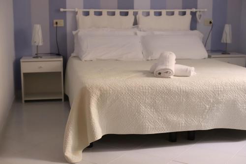 Una cama blanca con una toalla encima. en Pavì Delle 5 Terre, en Vernazza
