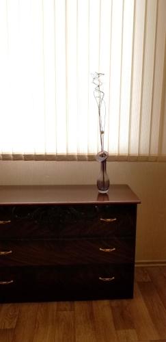 a vase on a dresser in front of a window at Lenina 7 in Tiraspol