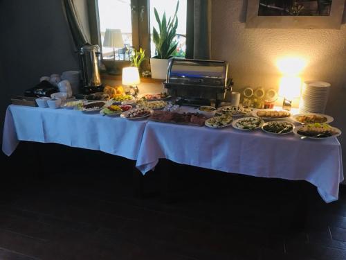 a table with many plates of food on it at Pensjonat Bajdarka in Suraż