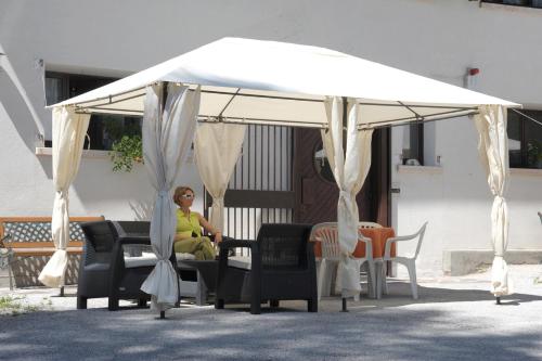 a woman sitting under a white canopy at Residence Regina Delle Dolomiti in Rocca Pietore