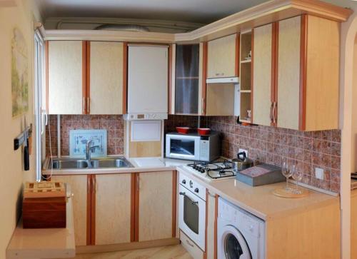 a kitchen with a sink and a microwave at Студия на Соборной in Mykolaiv