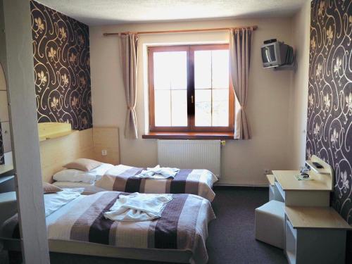 Łóżko lub łóżka w pokoju w obiekcie Hotel U Loubů