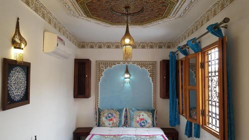een slaapkamer met een bed, een plafond en ramen bij Dar Nour Fes in Fès
