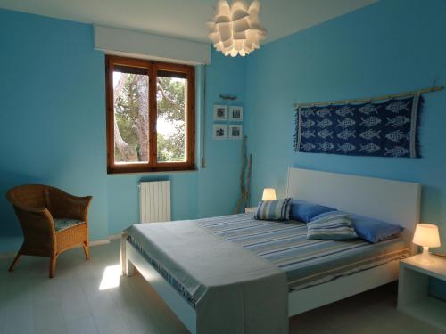 una camera da letto blu con un letto e una finestra di La casa di Nina a Quercianella