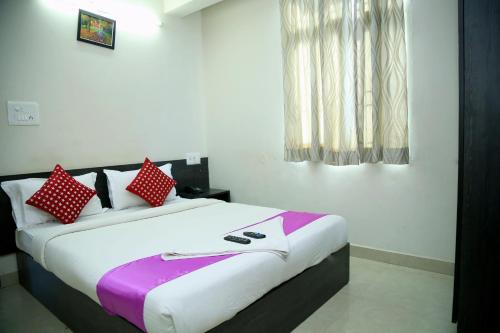 a bedroom with a large bed with red and white pillows at Orange Corner, Near Kempegowda Bangalore international airport in Bangalore