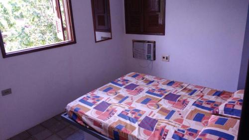 1 dormitorio con 1 cama con edredón en Chalés Recanto dos Golfinhos, en Ponta do Funil