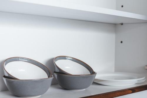 three bowls sitting on a shelf with plates at Dura Villas Bali at Kerobokan in Kerobokan