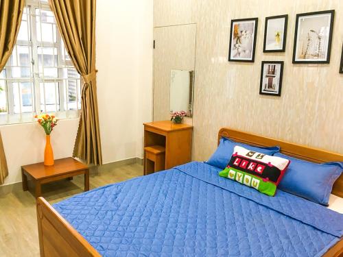 - une chambre avec un lit bleu et une couette bleue dans l'établissement 202s Homestay, à Quy Nhơn