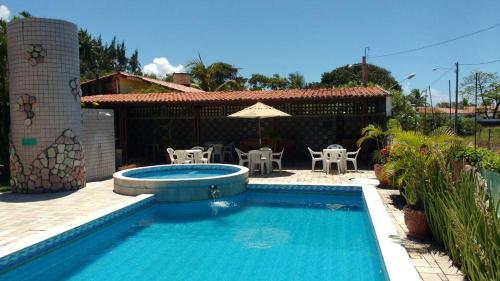 - une piscine en face d'une maison dans l'établissement Chalés Recanto dos Golfinhos, à Ponta do Funil