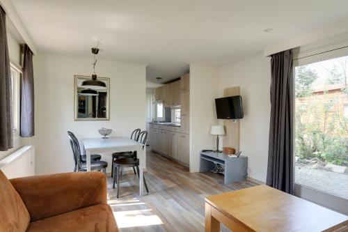 a living room with a couch and a table at Bungalowpark Het Verscholen Dorp in Harderwijk