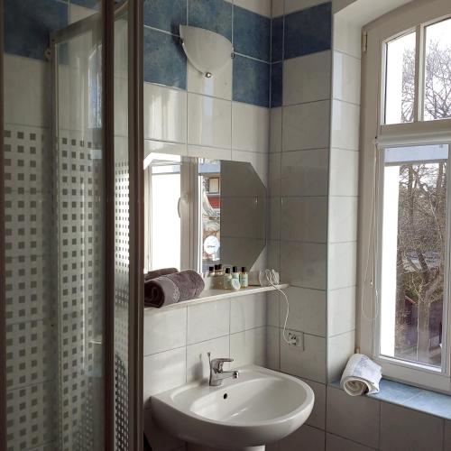 a bathroom with a sink and a mirror at Willa Warta in Krynica Morska