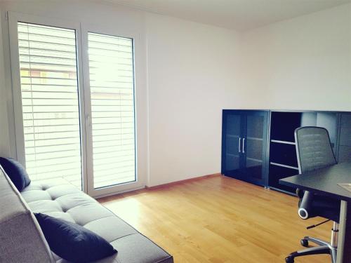 a living room with a couch and a table and chairs at Easy-Living Apartments Dietwil in Dietwil