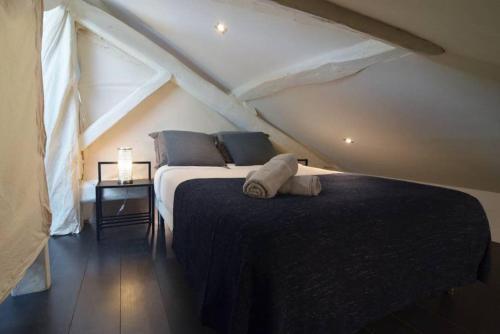 Duplex Elegant & Moderne - 3 chambres - Rooftop terrasse & Jacuzzi- Chélitz في بياريتز: غرفة نوم بسرير كبير في العلية