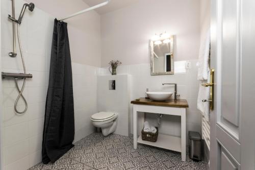 a white bathroom with a sink and a toilet at Villa Lenka in Tiszafüred