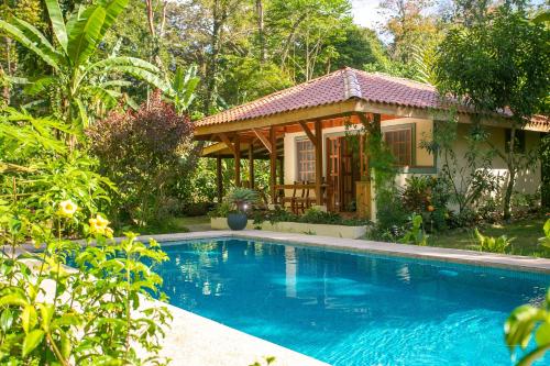 una casa con piscina di fronte a una casa di Hotel Casa Merlin a Puerto Viejo