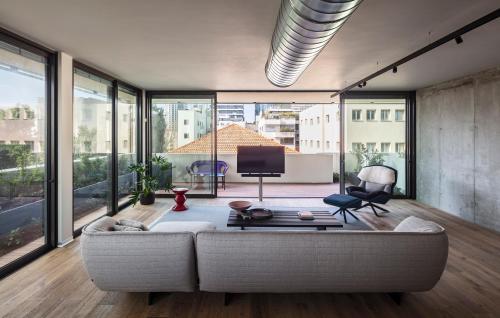 a living room with a couch and large windows at The Levee in Tel Aviv