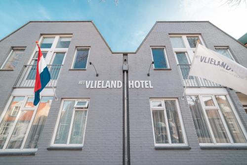 a building with a flag and a hotel at Het Vlielandhotel in Oost-Vlieland