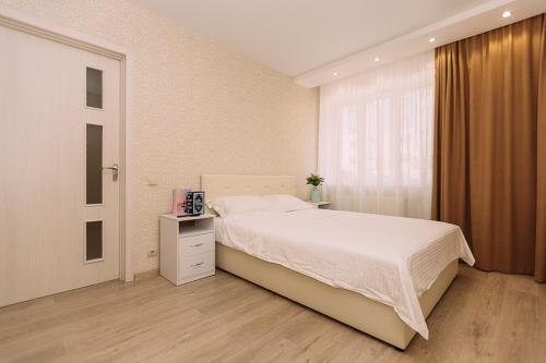 Un dormitorio con una cama grande y una ventana. en Люкс апартамента на Харьковской возле ТЦ Лавина, en Sumy