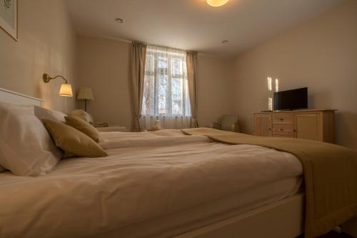 a bedroom with a large white bed with a window at Villa Lenka in Tiszafüred