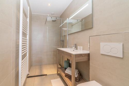 een badkamer met een wastafel en een spiegel bij Het Vlielandhotel in Oost-Vlieland
