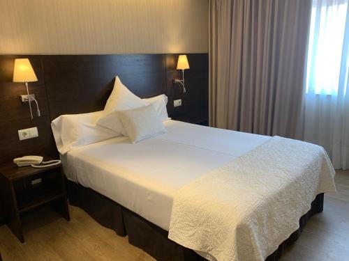 a bedroom with a large bed with white sheets and pillows at Montemar in Llanes