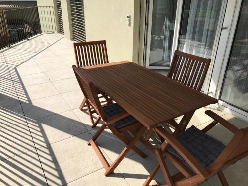 a wooden table and two chairs on a balcony at Easy-Living Apartments Dietwil in Dietwil