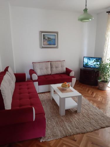a living room with a red couch and a coffee table at Nijona 1 in Trebinje