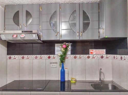 una cocina con un jarrón azul con una flor. en Escocie - Vargas, en Quito