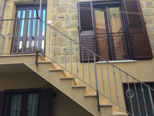 a building with a staircase and some windows at la casa di laura in Calascibetta