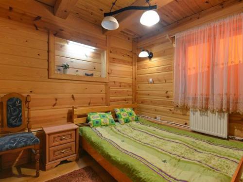 a bedroom with a bed in a wooden cabin at Gajówka Sajczyce - gospodarstwo agroturystyczne in Chełm