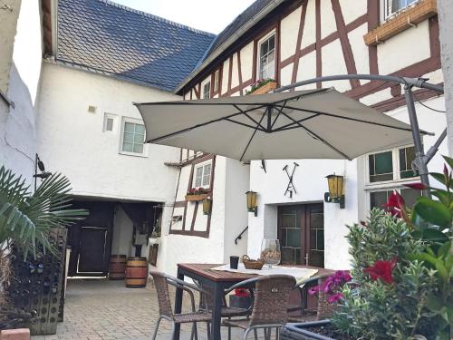 a table with an umbrella in front of a building at Fewo Zur Goldenen Traube in Rüdesheim am Rhein