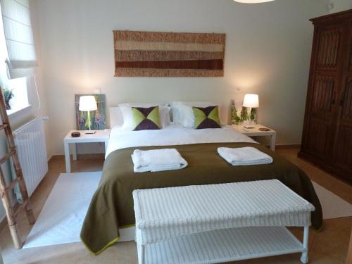 a bedroom with a large bed with two tables and two lamps at Casal das Oliveiras in Setúbal