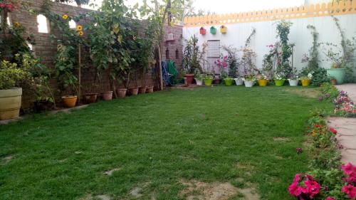a garden with plants and flowers in a yard at Coral Country Homestay in Agra