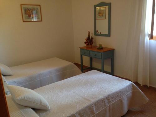 a room with two beds and a table with a mirror at Casa Victor in Playa Migjorn