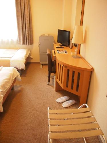 a hotel room with a desk with a computer and a chair at Nest Hotel Kumamoto in Kumamoto