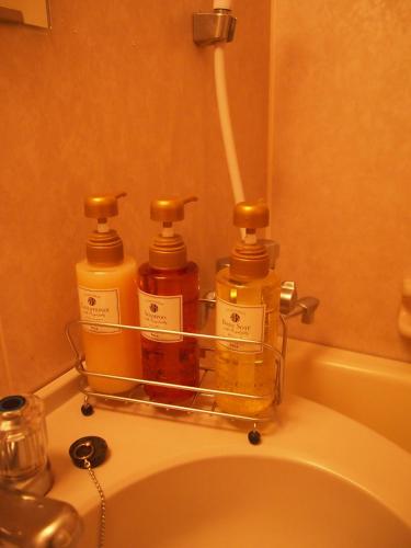 three bottles of honey sitting on top of a toilet at Nest Hotel Kumamoto in Kumamoto