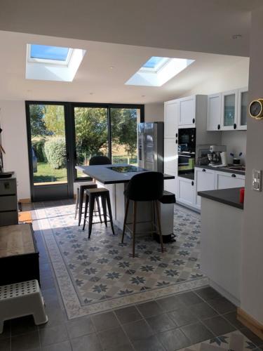 une cuisine avec une table et des chaises dans une pièce dans l'établissement Maison familiale au calme/5 chambres/Grand jardin, à Bangor