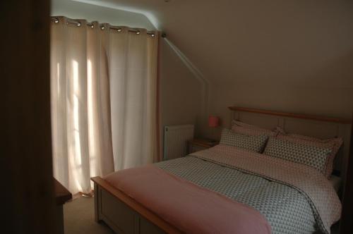 a bedroom with a bed and a white curtain at The Winning Post, Bruton in Bruton