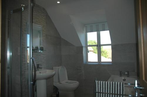 a bathroom with a sink and a toilet and a tub at The Winning Post, Bruton in Bruton