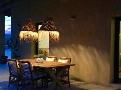 a dining room table with chairs and two chandeliers at Monte da Aparica in Galeguinha Grande