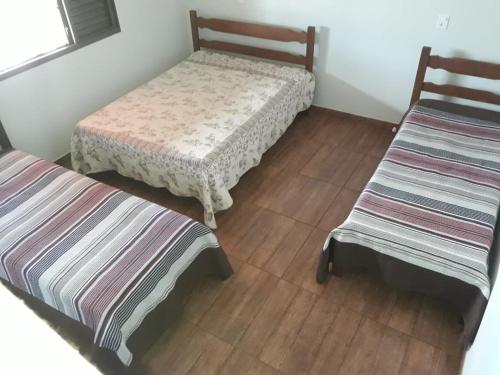 a room with two beds and a chair at Sítio Luar in São Roque de Minas