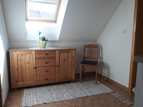 a room with a wooden dresser and a chair at Russhof-Fam.Thomann in Stainz