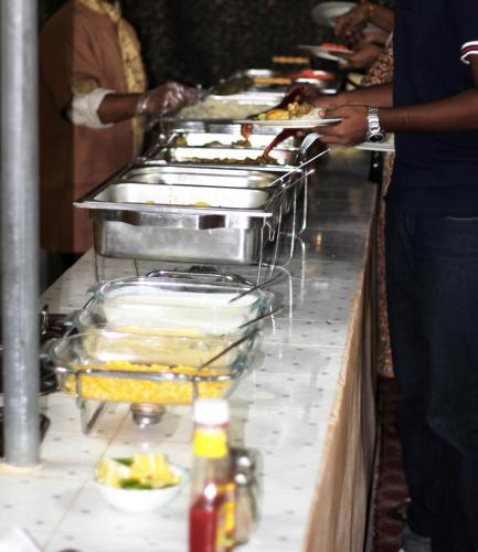 a buffet line with many trays of food at Bidiya Desert Camp in Aflāj